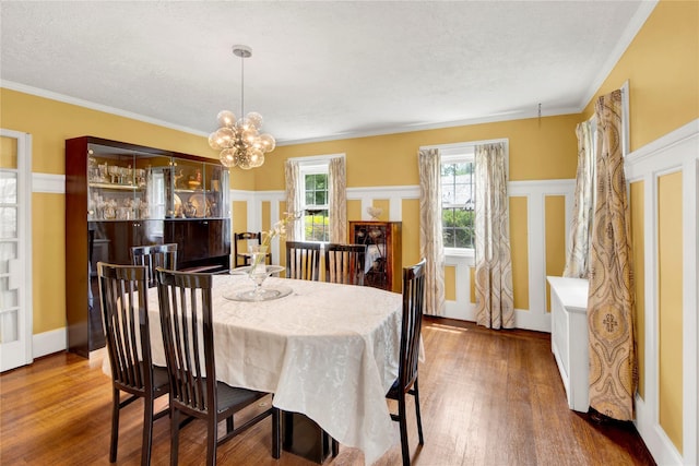 431 E Sidney Ave, Mount Vernon, NY 10553 - dining area with wood finished floors, a textured ceiling, a chandelier, ornamental molding, and a decorative wall