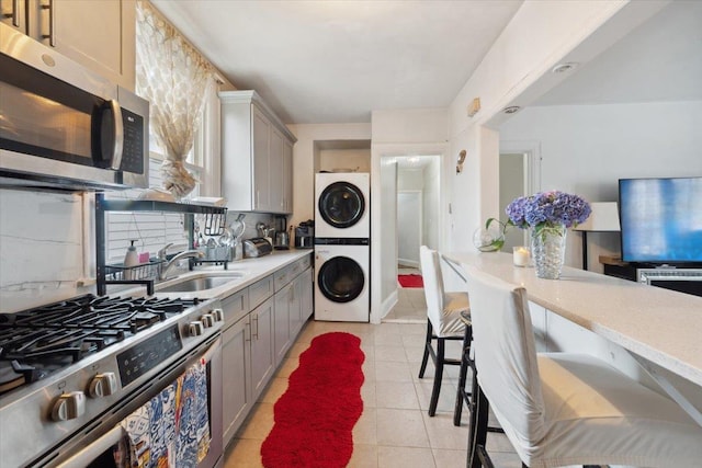 317 Hawthorne Ave, Yonkers, NY 10705 - kitchen with appliances with stainless steel finishes, stacked washer and clothes dryer, gray cabinetry, and light countertops