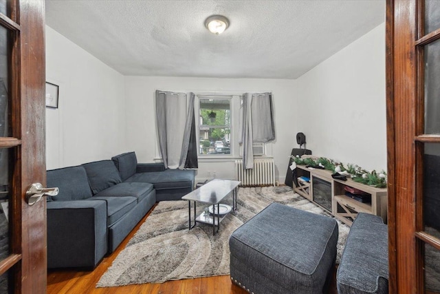 317 Hawthorne Ave, Yonkers, NY 10705 - living room featuring radiator, a textured ceiling, and wood finished floors