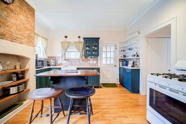 12 Beechwood Ter, Poughkeepsie, NY 12601 - kitchen with white range with gas stovetop, blue cabinetry, wooden counters, a kitchen breakfast bar, and ornamental molding