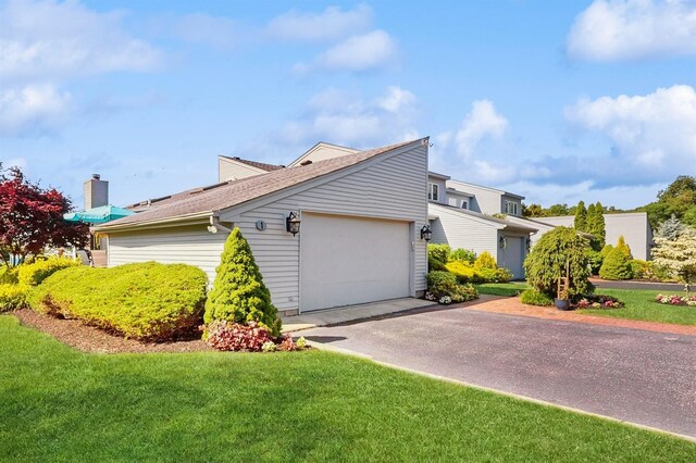 1 Harbour Unit 1, Blue Point, NY 11715 - view of side of property with asphalt driveway, a yard, a garage, and roof with shingles