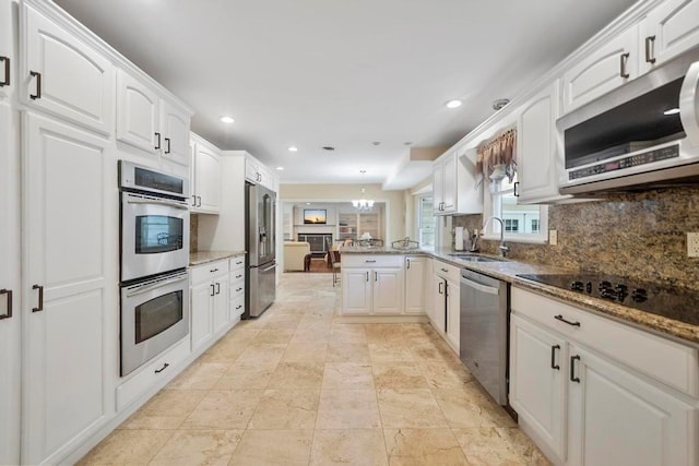 15 Stillwood Rd, Brookhaven, NY 11719 - kitchen featuring stainless steel appliances, a peninsula, white cabinetry, tasteful backsplash, and light stone countertops