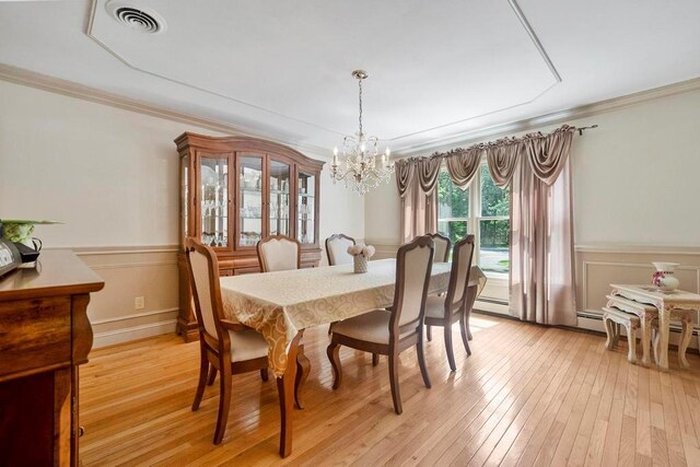 15 Stillwood Rd, Brookhaven, NY 11719 - dining area featuring a chandelier, ornamental molding, light wood finished floors, and wainscoting