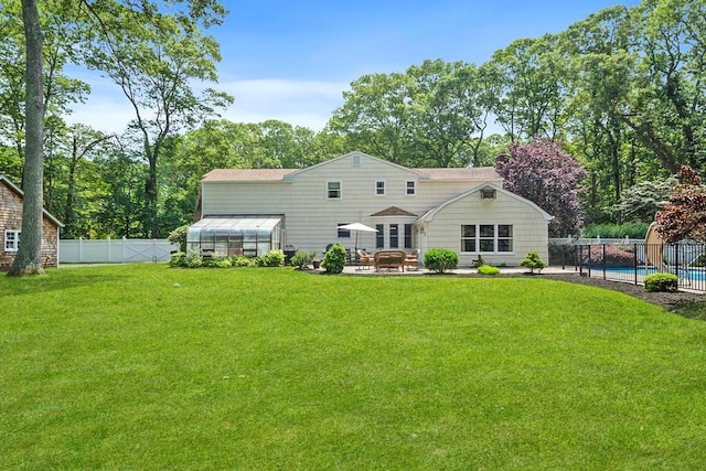 15 Stillwood Rd, Brookhaven, NY 11719 - rear view of property featuring a greenhouse, a fenced backyard, an outbuilding, and a patio