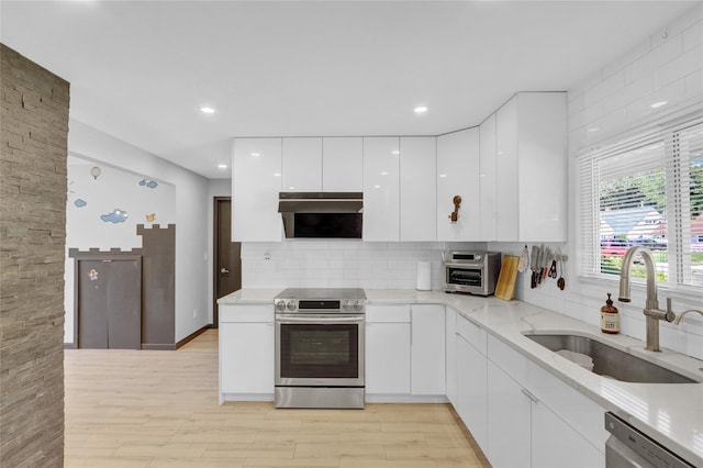 206 Friends Ln, Westbury, NY 11590 - kitchen with stainless steel appliances, ventilation hood, modern cabinets, white cabinetry, and backsplash