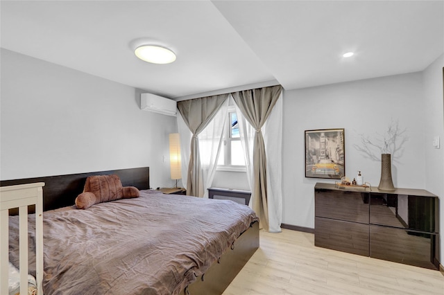 206 Friends Ln, Westbury, NY 11590 - bedroom with a wall mounted air conditioner, light wood-style floors, and recessed lighting