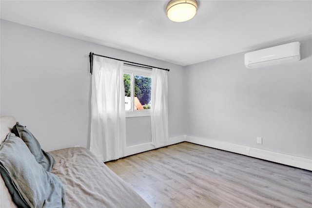 206 Friends Ln, Westbury, NY 11590 - unfurnished room with an AC wall unit and wood finished floors