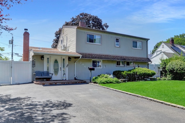 206 Friends Ln, Westbury, NY 11590 - traditional-style home featuring a porch and a chimney