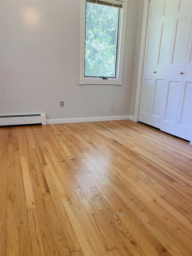 190 Springdale Dr, Ronkonkoma, NY 11779 - unfurnished bedroom with a baseboard heating unit and light wood-type flooring