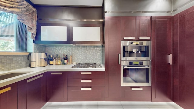 20 Corbin Pl, Brooklyn, NY 11235 - kitchen with stainless steel gas cooktop, light countertops, decorative backsplash, reddish brown cabinets, and modern cabinets