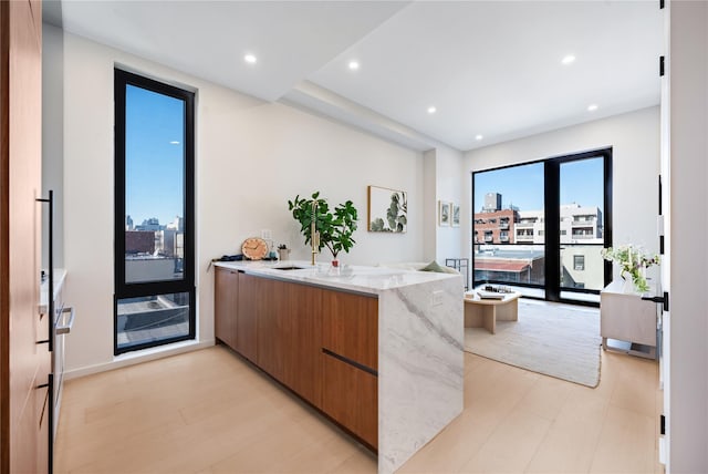 3116 21st St Unit Ph2F, Astoria, NY 11106 - kitchen with modern cabinets, a peninsula, light stone countertops, brown cabinets, and recessed lighting