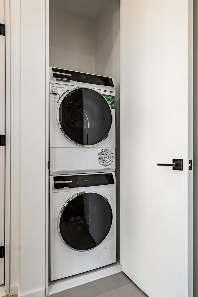 3116 21st St Unit Ph2F, Astoria, NY 11106 - washroom with stacked washer / drying machine and wood finished floors