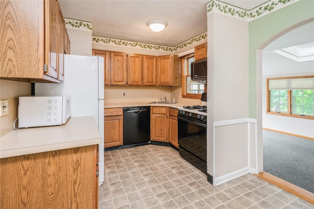 5 Hillaire Pl, Nanuet, NY 10954 - kitchen featuring black appliances, arched walkways, light countertops, and brown cabinetry