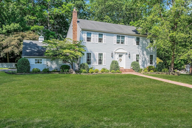 2 Seaview Ln, Mount Sinai, NY 11766 - colonial-style house with a chimney, a front lawn, and a shingled roof
