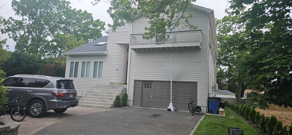1018 E Broadway, Woodmere, NY 11598 - view of front of home with a balcony, driveway, and an attached garage