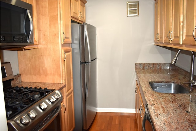 596 Broadway Unit 10B, Lynbrook, NY 11563 - kitchen featuring appliances with stainless steel finishes, wood finished floors, and light stone counters