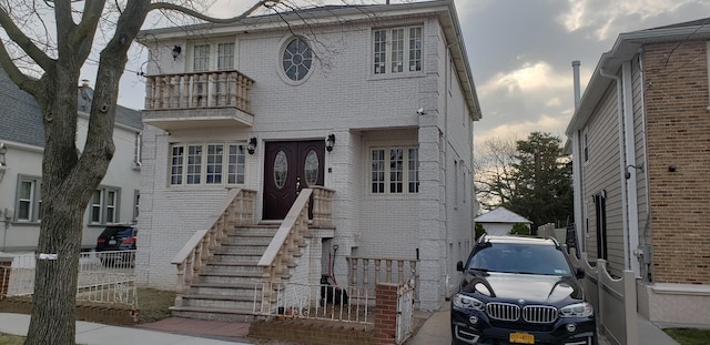 13035 126th S, Ozone Park, NY 11420 - view of front facade with a balcony, brick siding, and entry steps