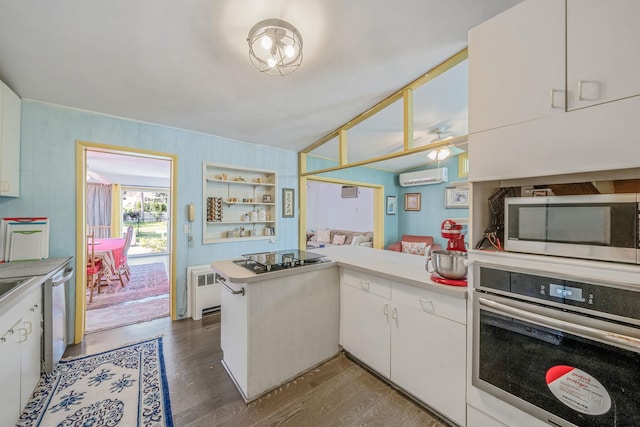 26 Liber Blvd, Farmingville, NY 11738 - kitchen with appliances with stainless steel finishes, a wall mounted air conditioner, a peninsula, radiator heating unit, and dark wood-style floors
