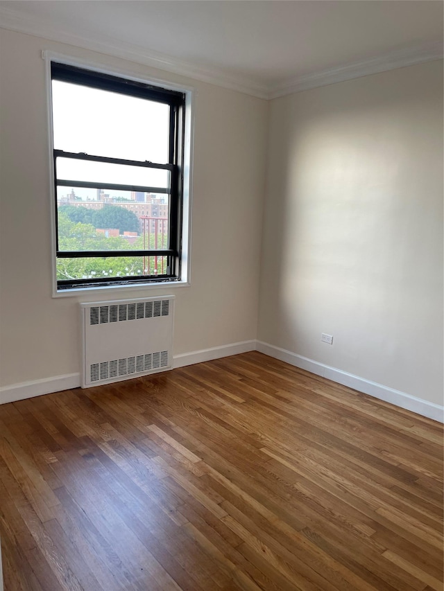 150-15 72nd Rd Unit 4G, Flushing, NY 11367 - unfurnished room with radiator heating unit, crown molding, and wood finished floors