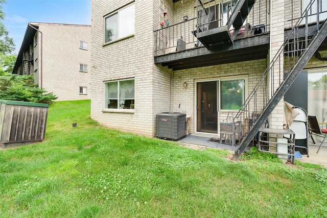 26 Cooper Rd Unit 416, Poughkeepsie, NY 12603 - rear view of property featuring a balcony, brick siding, and a yard