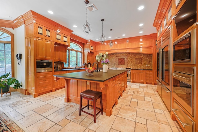 11 Black Rock Rd, Muttontown, NY 11545 - kitchen with built in appliances, stone tile flooring, dark countertops, decorative backsplash, and an island with sink