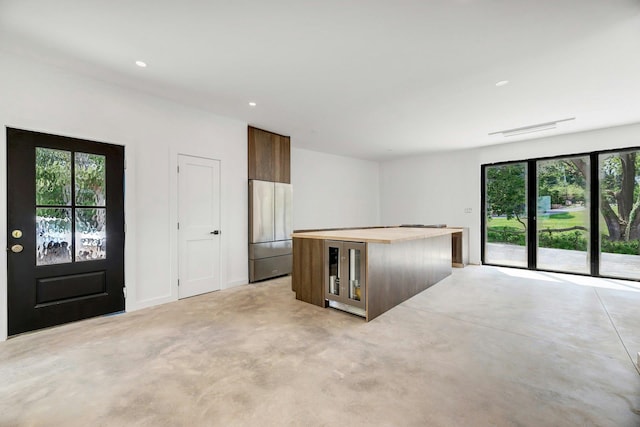 410 Aquaview Ave, East Marion, NY 11939 - kitchen with wine cooler, a center island, stainless steel fridge, recessed lighting, and dark brown cabinets