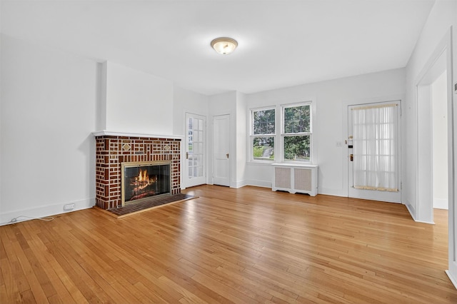 175 N Regent St, Port Chester, NY 10573 - unfurnished living room with radiator, light wood-style floors, and a fireplace