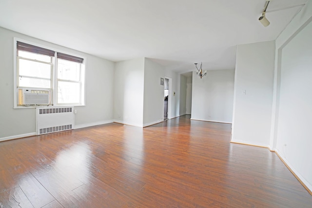 5621 Netherland Ave Unit 5C, Bronx, NY 10471 - spare room featuring radiator, a chandelier, cooling unit, and wood finished floors