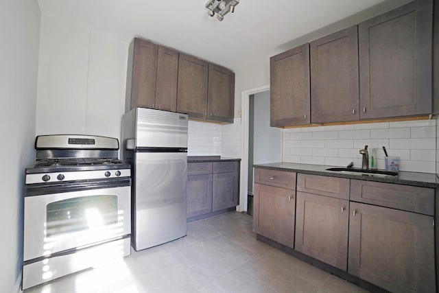5621 Netherland Ave Unit 5C, Bronx, NY 10471 - kitchen with stainless steel appliances, backsplash, light tile patterned flooring, and dark stone counters