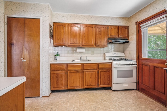 337 Atlantic Ave, Massapequa Park, NY 11762 - kitchen featuring white gas stove, wallpapered walls, brown cabinets, light countertops, and extractor fan