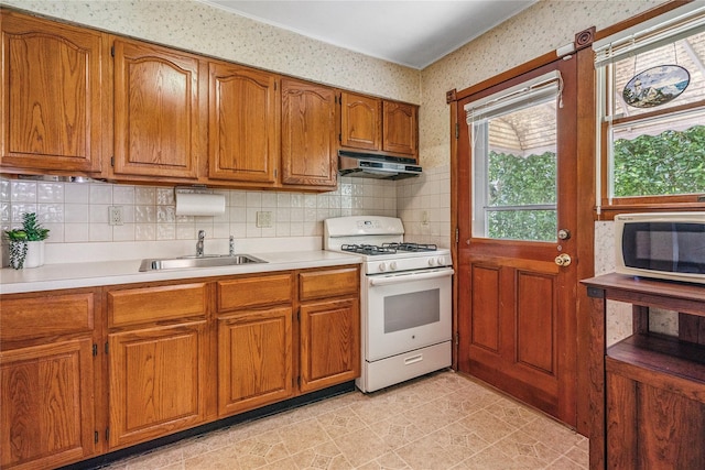 337 Atlantic Ave, Massapequa Park, NY 11762 - kitchen featuring white gas range oven, range hood, brown cabinets, light countertops, and wallpapered walls