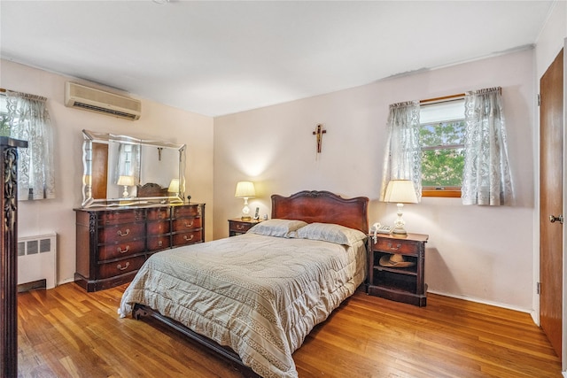 337 Atlantic Ave, Massapequa Park, NY 11762 - bedroom with radiator, wood finished floors, and an AC wall unit
