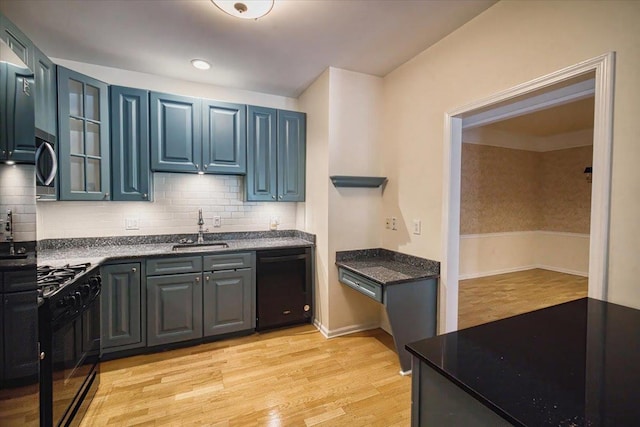 26 N De Baun Ave Unit 303, Suffern, NY 10901 - kitchen with black appliances, glass insert cabinets, light wood-type flooring, and backsplash
