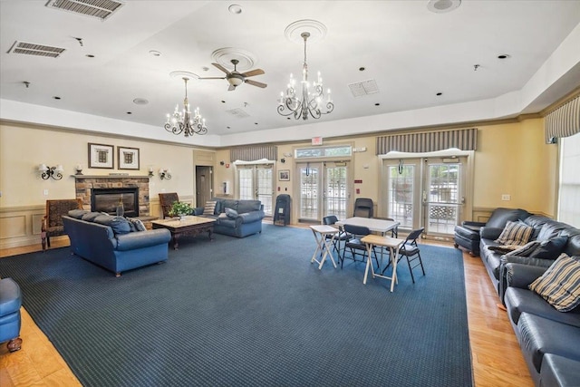 26 N De Baun Ave Unit 303, Suffern, NY 10901 - living room with a chandelier, french doors, a fireplace, wainscoting, and light wood-style flooring