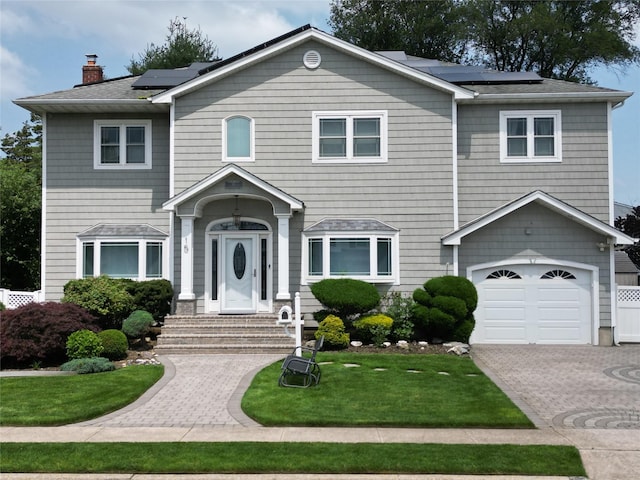15 Cedar Dr E, Plainview, NY 11803 - view of front of house featuring solar panels, entry steps, a front lawn, and a garage
