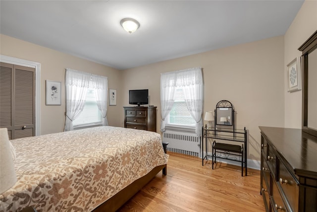 231 Wilson St, West Hempstead, NY 11552 - bedroom with radiator heating unit, light wood-style floors, and a closet