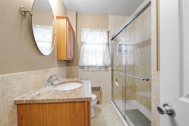231 Wilson St, West Hempstead, NY 11552 - bathroom with radiator, tile walls, a shower stall, vanity, and tile patterned floors