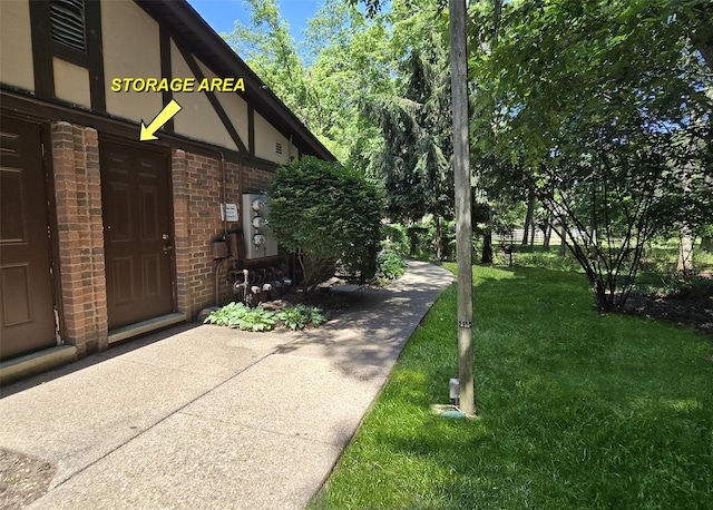 23 Birchwood Rd Unit 23, Coram, NY 11727 - view of side of home featuring brick siding, a yard, and stucco siding