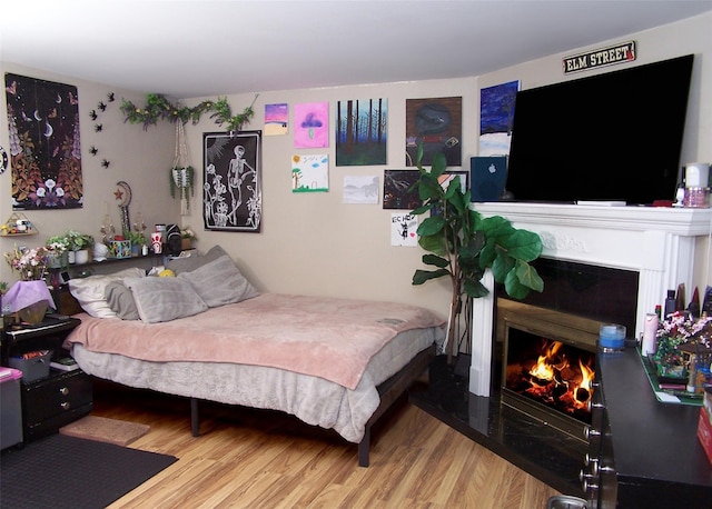 23 Birchwood Rd Unit 23, Coram, NY 11727 - bedroom featuring a fireplace with flush hearth and wood finished floors