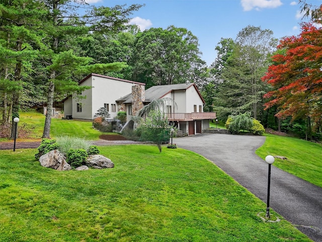 35 Greenlawn Rd, Amawalk, NY 10501 - mid-century modern home with an attached garage, driveway, a front lawn, and stucco siding