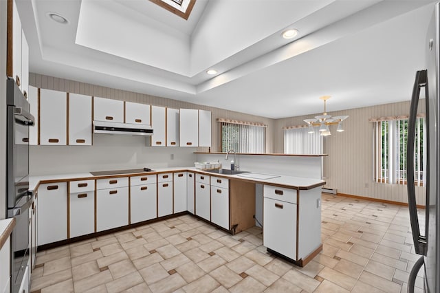 35 Greenlawn Rd, Amawalk, NY 10501 - kitchen with a peninsula, white cabinetry, under cabinet range hood, light countertops, and a chandelier
