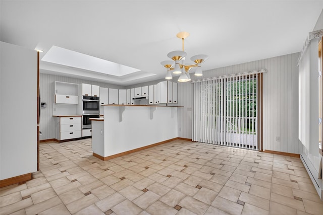 35 Greenlawn Rd, Amawalk, NY 10501 - kitchen with double oven, a peninsula, a chandelier, a breakfast bar, and decorative light fixtures