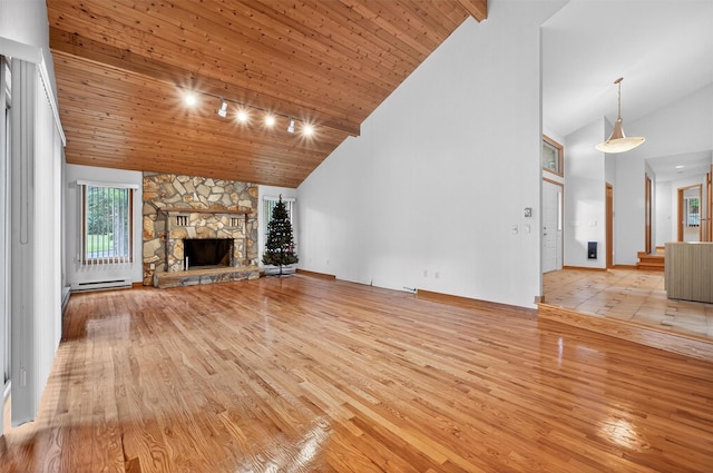 35 Greenlawn Rd, Amawalk, NY 10501 - unfurnished living room featuring hardwood / wood-style floors, high vaulted ceiling, a stone fireplace, baseboard heating, and wood ceiling