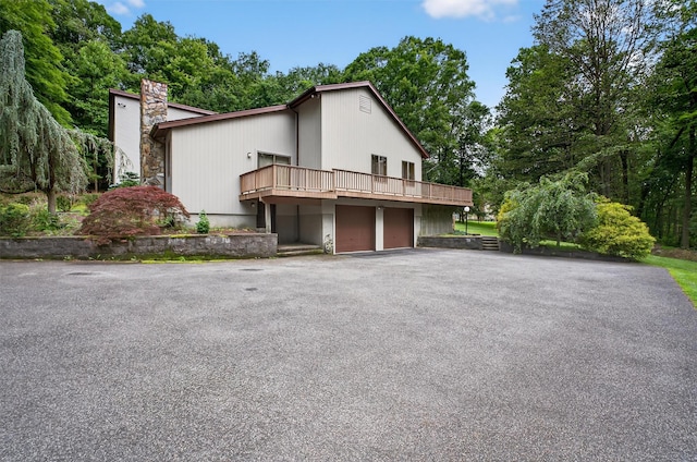 35 Greenlawn Rd, Amawalk, NY 10501 - view of home's exterior featuring a chimney, a garage, asphalt driveway, and a wooden deck