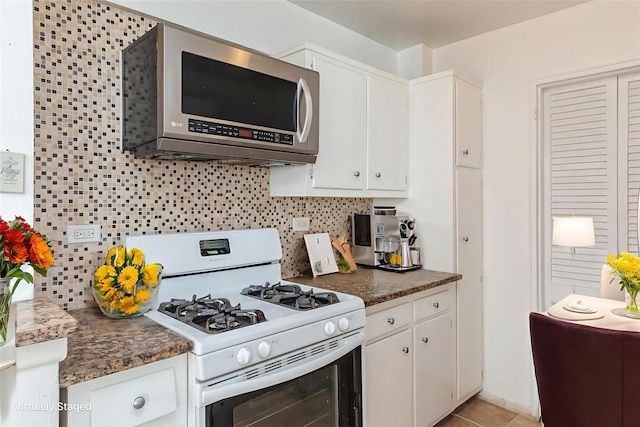 99-10 60th Ave Unit C1C, Corona, NY 11368 - kitchen with white gas range oven, stainless steel microwave, backsplash, white cabinets, and dark countertops