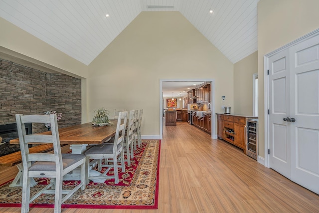 246 Cadman Ave, Babylon, NY 11702 - dining area featuring beverage cooler, high vaulted ceiling, and light wood-style flooring