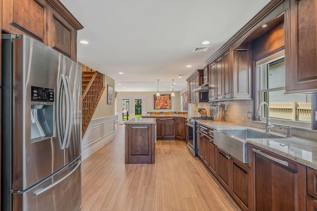 246 Cadman Ave, Babylon, NY 11702 - kitchen featuring appliances with stainless steel finishes, light wood-style flooring, light stone countertops, pendant lighting, and backsplash