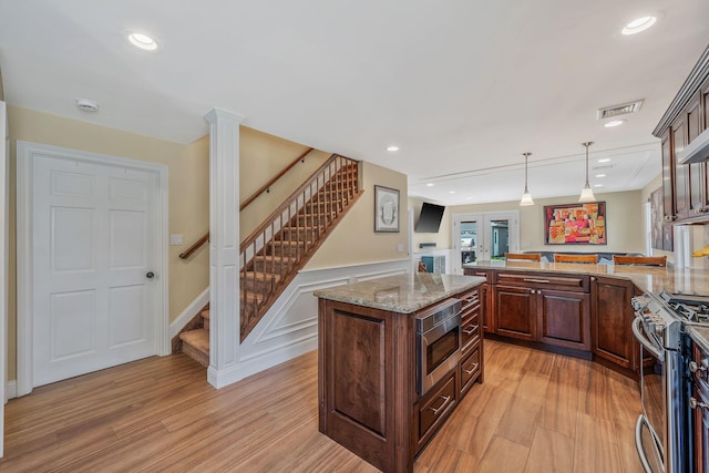 246 Cadman Ave, Babylon, NY 11702 - kitchen with appliances with stainless steel finishes, light wood-type flooring, a peninsula, hanging light fixtures, and light stone countertops