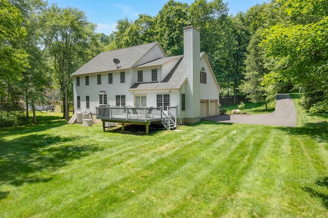 76 Warren St, Somers, NY 10589 - back of property with a garage, a wooden deck, asphalt driveway, a lawn, and a chimney