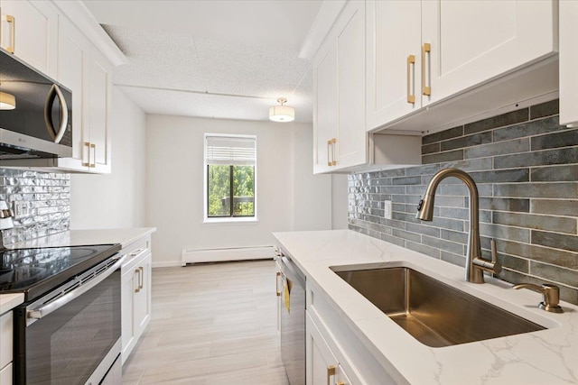 50 Columbus Ave Unit 611, Tuckahoe, NY 10707 - kitchen featuring appliances with stainless steel finishes, a baseboard radiator, white cabinetry, and tasteful backsplash